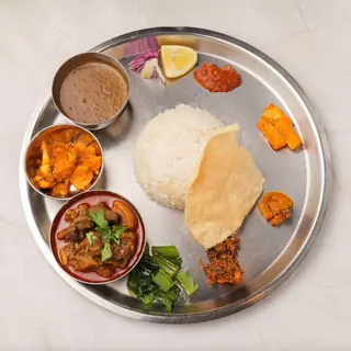 Traditional Nepali goat thali set — steamed rice with curry, dal, seasonal vegetables and achar at Laliguras Restaurant